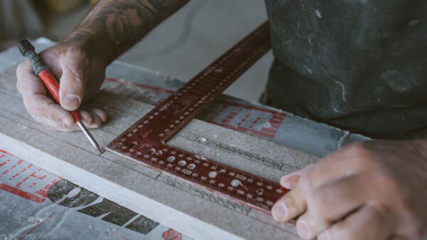 A tradesman drawing on concrete as part of a design and build project